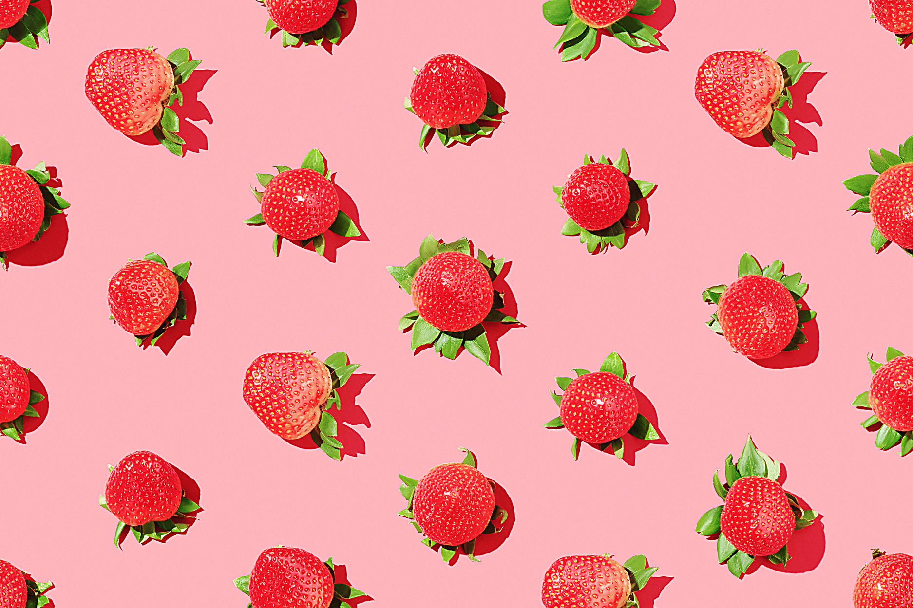 Strawberry pattern on a pink background. Juicy strawberries. Top view.